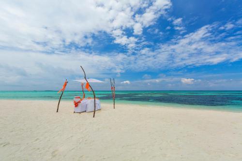 a chair on the beach with a wedding ceremony at Sun Siyam Olhuveli in South Male Atoll