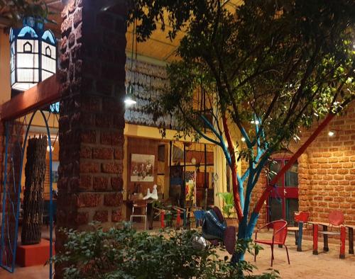 a brick building with a tree in front of it at Villa Yiri Suma in Ouagadougou