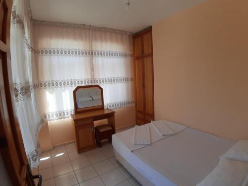 Cette petite chambre comprend un lit et une télévision. dans l'établissement ÖZNUR APART OTEL, à Sidé