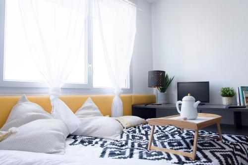 a bedroom with a bed with white pillows and a table at Sweetly Alexandrin Toulouse in Toulouse
