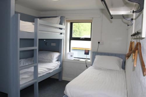 a bedroom with two bunk beds and a window at FSC Millport Hostel in Millport