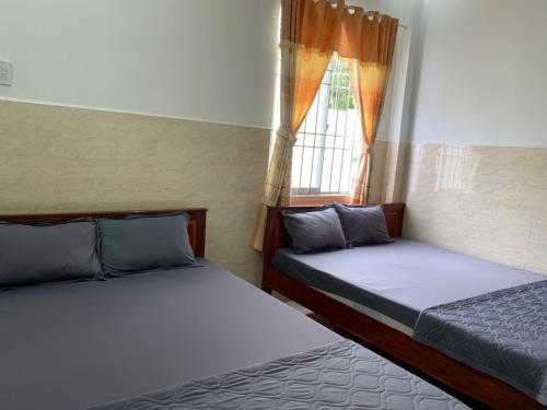 2 camas en una habitación con ventana en Nha Nghi Ty Hoa Nam Du en Nam Du