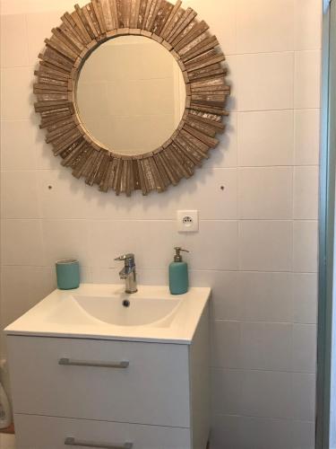 une salle de bain avec un lavabo et un miroir dans l'établissement La petite Escarpolette, à Arzon