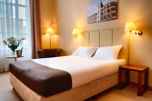 a hotel room with a large bed and a window at Focus Hotel Łódź in Łódź