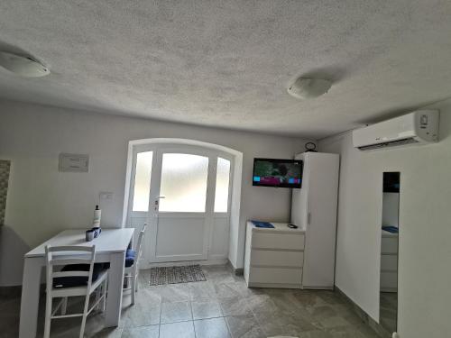 a room with a kitchen with a table and a refrigerator at Studio Apartment Mileta in Pitve