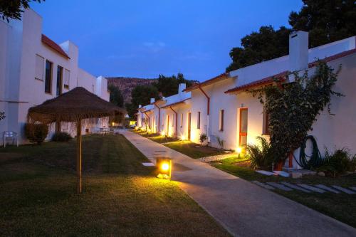 a row of white buildings with lights in the grass at Aldeamento Turístico do Camarido, Nature & Beach Resort in Caminha