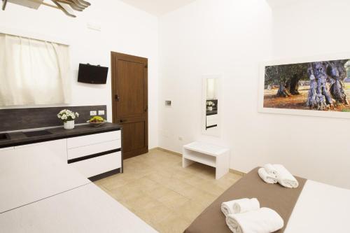 a white kitchen with a sink and a counter at La Casina Di Borgagne in Borgagne