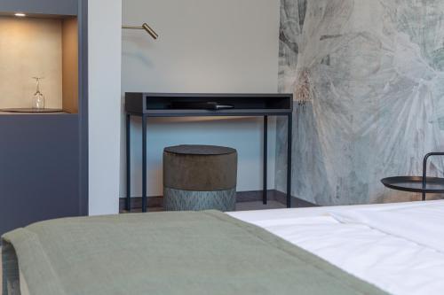 a bedroom with a bed and a table and a stool at Parkhotel Schmid in Adelsried