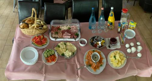 a pink table topped with plates of food and drinks at Pension am See in Kremmen
