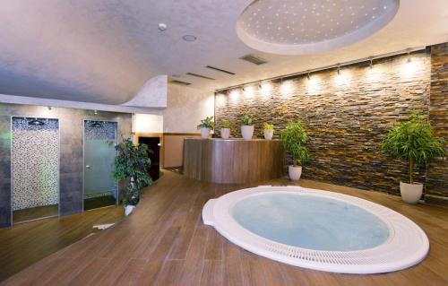 a large bathroom with a large tub with plants in it at Garni Hotel Aleksandar in Novi Sad