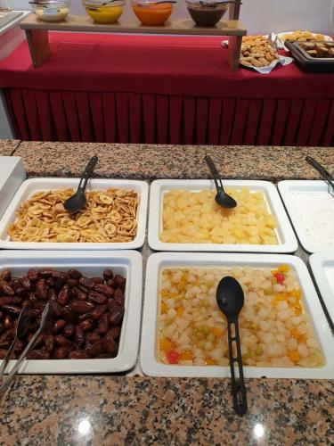 four trays of food on a counter with spoons at Sidari Waterpark in Sidari