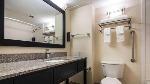 a bathroom with a toilet and a sink and a mirror at Best Western Mulberry Hotel in Mulberry