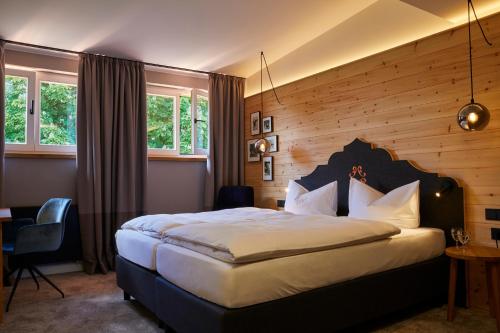 1 dormitorio con 1 cama grande y pared de madera en Aschbacher Hof en Feldkirchen-Westerham