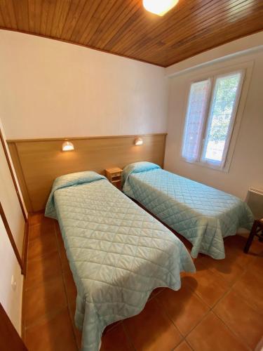 une chambre avec deux lits dans une pièce dans l'établissement Les Gîtes, à Jausiers