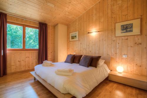 - une chambre avec un grand lit dans un mur en bois dans l'établissement Villa Chimera, à Poppi