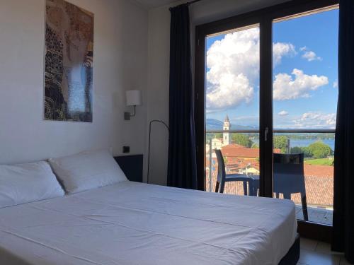 a bedroom with a white bed and a large window at Hotel La Locanda in Cadrezzate