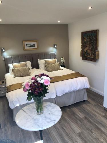 um quarto com duas camas e uma mesa com um vaso de flores em Jonan House em Deal