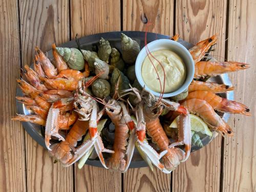 a plate of shrimp and vegetables with a bowl of dipping sauce at Hôtel de La Plage - WISSANT in Wissant