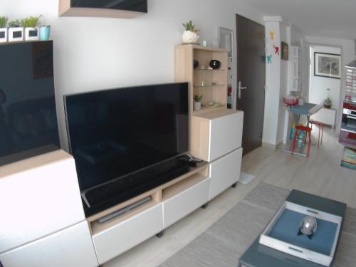 Una sala de estar con un televisor de pantalla plana grande. en LePéri5scope, en Berck-sur-Mer