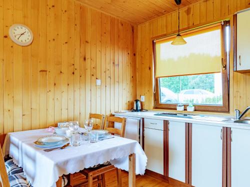 a kitchen with a table and a clock on the wall at Domki Victoria in Ustka
