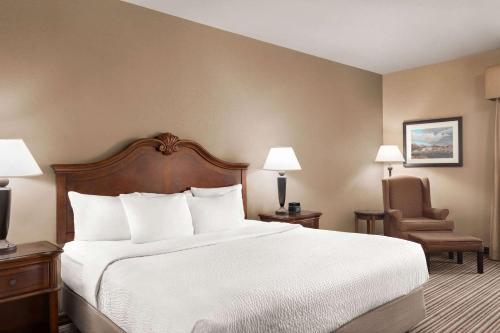 a hotel room with a large bed and a chair at La Quinta by Wyndham Trinidad in Trinidad