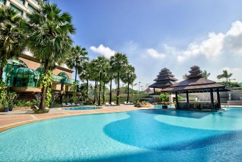 a large swimming pool next to a building with palm trees at Sedona Hotel Yangon in Yangon