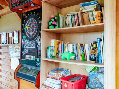 a book shelf filled with books and a clock at Domki Victoria in Ustka