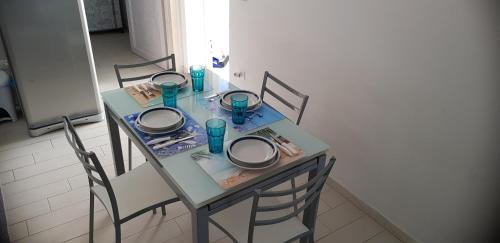 a dining room table with chairs and a table with dishes on it at Leuca Mon Amour in Leuca