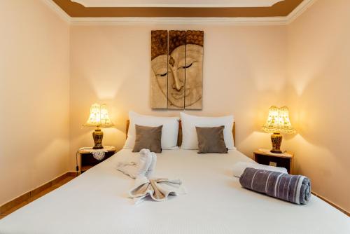 a bedroom with a large white bed with two lamps at Villa Katarina in Labin