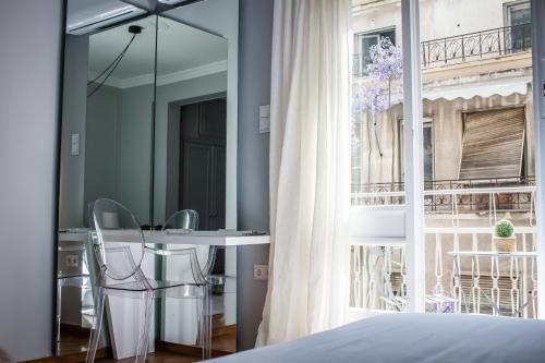 a bedroom with a table and chairs next to a window at API Projects Athens - Parliament Apartment in Athens