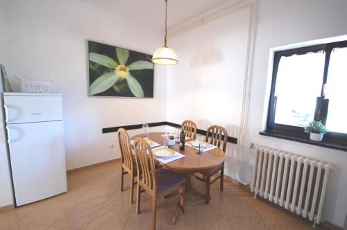 a kitchen with a table and chairs and a refrigerator at Apartment Margareta in Njivice