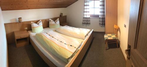 ein Schlafzimmer mit einem großen Bett in einem Zimmer in der Unterkunft Campedèl Hof in Kastelruth