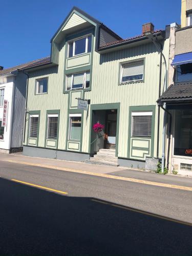 a green building on the side of a street at Larvik Pensjonat in Larvik