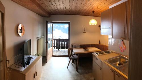 a kitchen with a desk and a table with a television at Campedèl Hof in Castelrotto