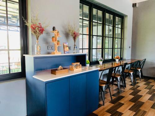 a long blue island in a room with chairs at Benwadee Resort Pattaya in Ban Pong