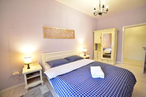 a bedroom with a blue and white bed and a mirror at Anna's Guest House in Sibiu