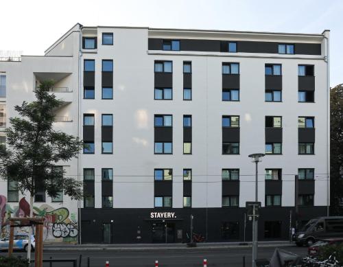 a white building with a sign on the side of it at STAYERY Berlin Friedrichshain - stylish Rooms & Apartments in Berlin