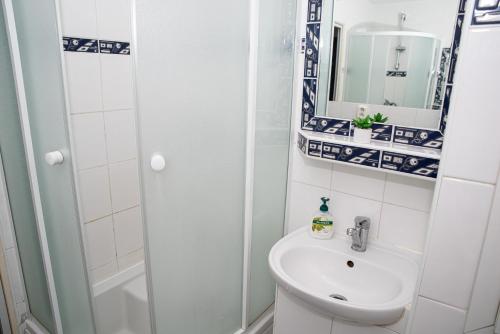 a white bathroom with a sink and a shower at LOVELY ONE BEDROOM APARTMENT in Nové Zámky