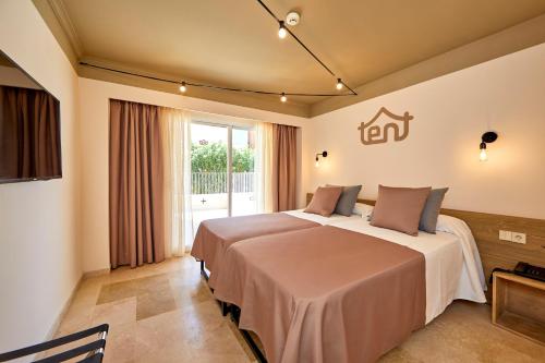 プラヤ・デ・パルマにあるtent Capi Playaのベッド2台と窓が備わるホテルルームです。