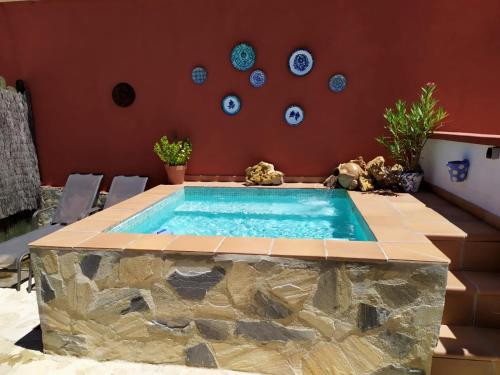 a swimming pool in a room with a table and chairs at CASA RURAL "LA CASITA" para 2 personas in Ronda