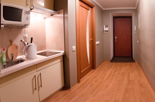 kuchnia ze zlewem i kuchenką mikrofalową w obiekcie Home Apartments w Kijowie