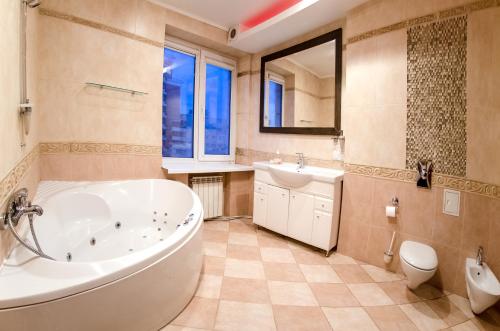 łazienka z wanną, umywalką i toaletą w obiekcie Home Apartments w Kijowie