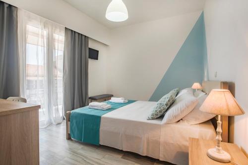 - une chambre dotée d'un lit avec un mur bleu dans l'établissement Magnolia Rooms, à Benitses