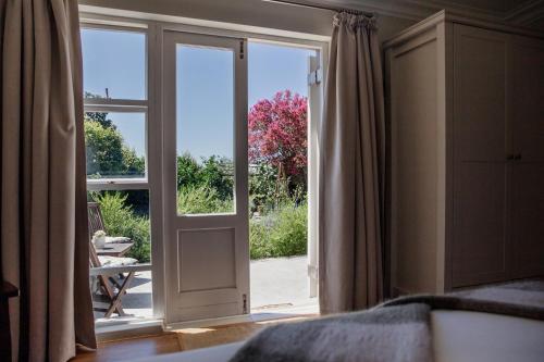 an open door with a view of a garden at Cornerstone Manor in Grahamstown