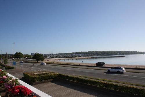 a car driving down a road next to a body of water at Hotel Østersø in Aabenraa