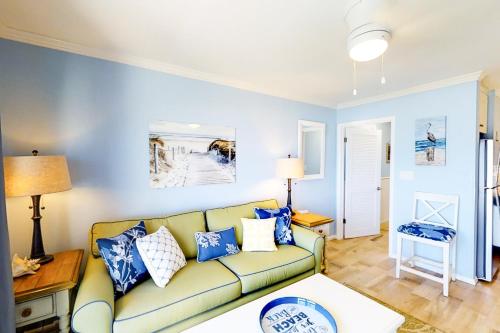 een woonkamer met een gele bank en blauwe muren bij Breakers 311 in Hilton Head Island