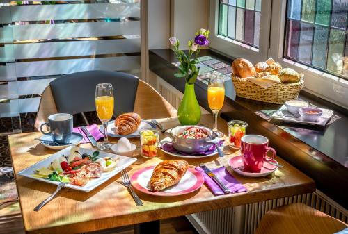 a table topped with plates of food and drinks at Insel Hotel Bonn - Superior in Bonn
