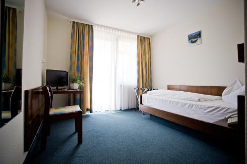 um quarto com uma cama, uma cadeira e uma janela em Hotel Lindenhof em Mosbach