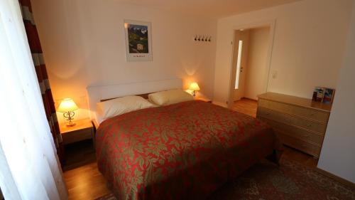 a bedroom with a red bed and two lamps at Ferienwohnung Bräu in Rauris