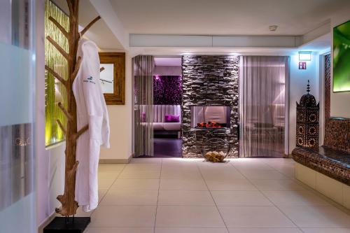 a bathroom with a fireplace and a robe on a wall at Insel Hotel Bonn - Superior in Bonn